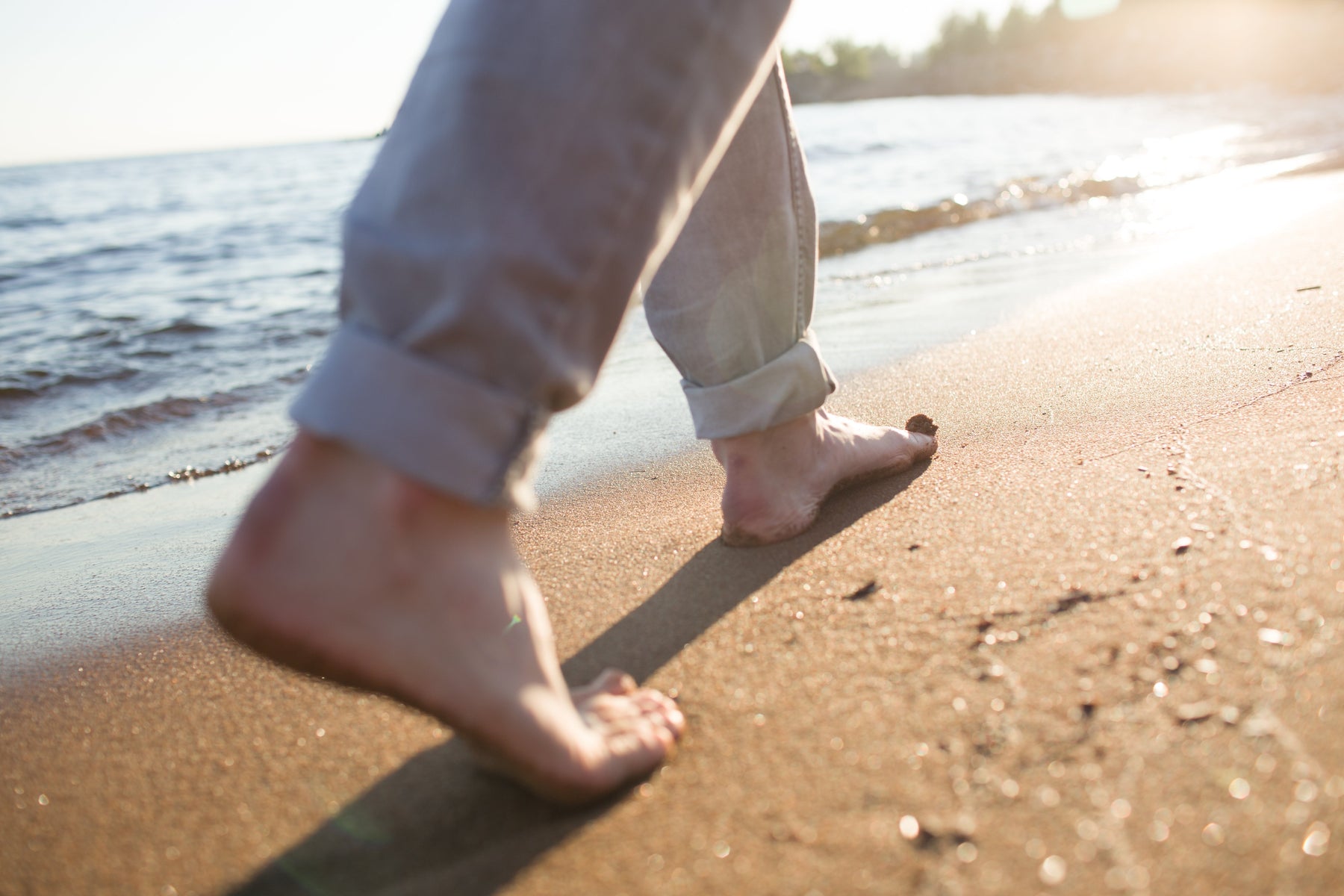 Person walking on the beach illustrating the concept of grounding (otherwise called earthing)